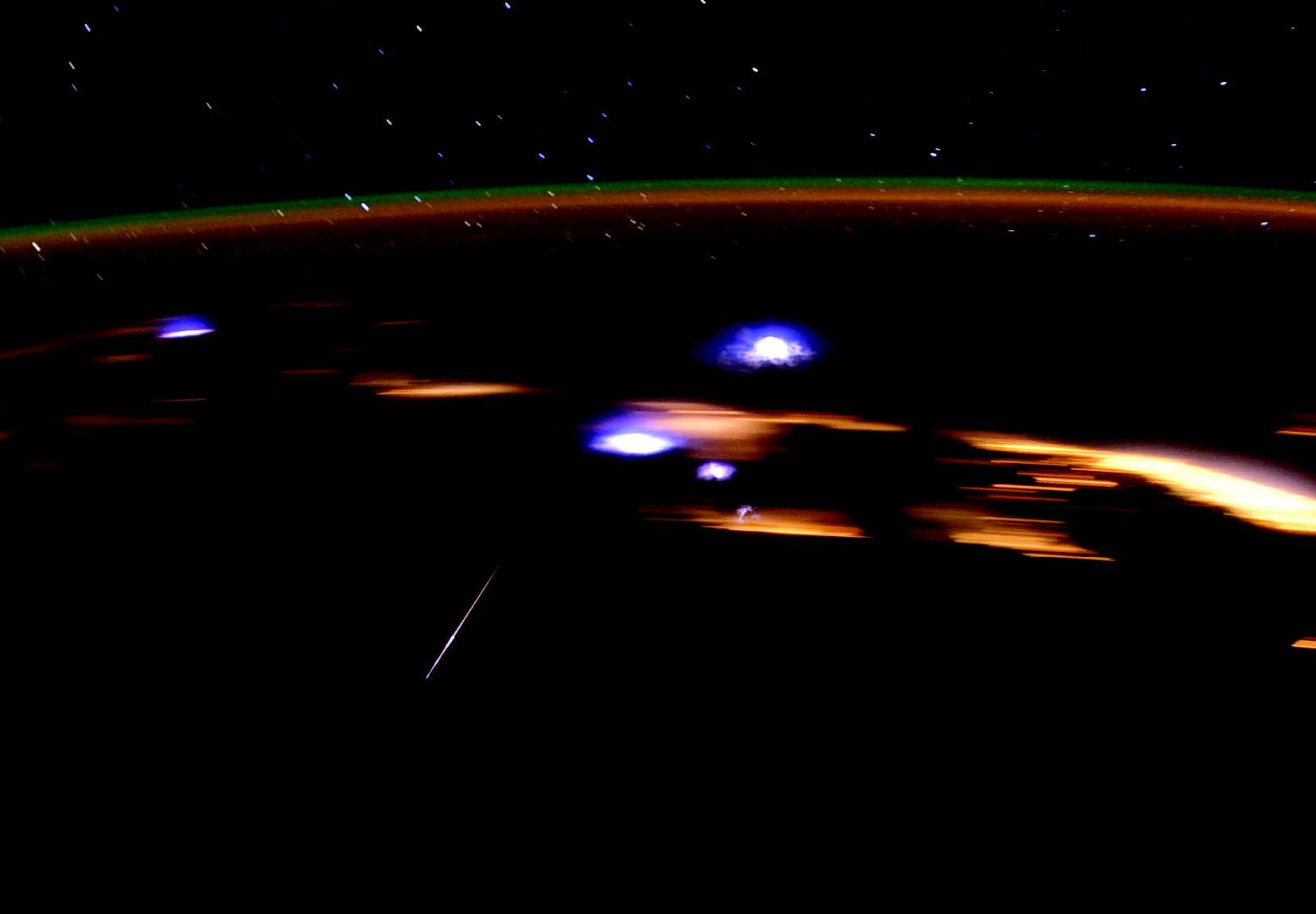 A crew member aboard the International Space Station photographed a Lyrid meteor streaking through the center left, in 2012. The space station was over the Gulf of Mexico, and many coastal cities in several states can be seen as blurry lights in the background. 