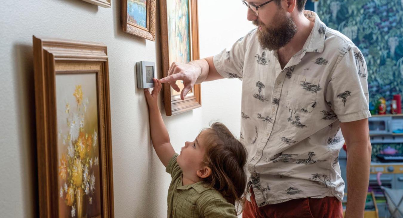 Father & Son adjusting thermostat together