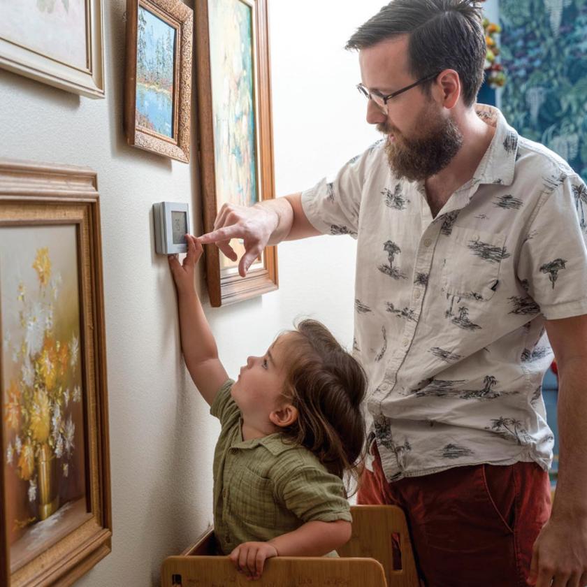 Father & Son adjusting thermostat together